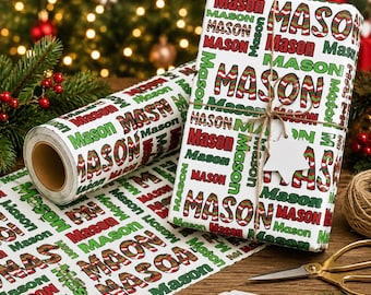 May include: A roll of white wrapping paper and a gift box wrapped in the same paper, both featuring the name Mason printed repeatedly in red, green, and a red-and-green striped pattern. The gift box is tied with twine and a star-shaped tag.