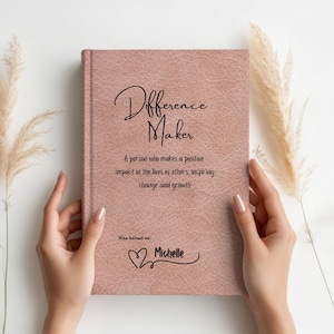May include: A pink leather-bound journal with the words "Difference Maker" and a quote about making a positive impact. The name "Michelle" is written in cursive with a heart symbol.
