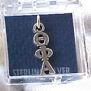May include: A silver charm with the letters "O.P.A." in a vertical stack. The charm is in a clear plastic box with the words "STERLING SILVER" printed on the bottom.