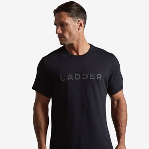 Puede incluir: Camiseta negra de cuello redondo con la palabra "LADDER" en relieve en el pecho. La camiseta tiene mangas cortas y un dise&ntilde;o minimalista. La tela parece ser un material suave y mate.