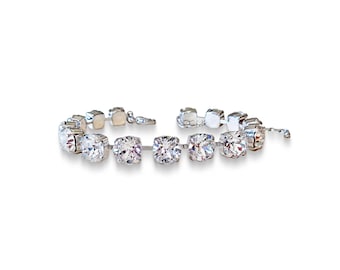 Bracciale tennis con pietre decorative Swarovski da 8 mm, cristallo trasparente, montatura placcata in argento rodiato.