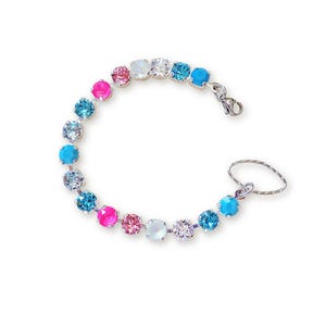 May include: A silver bracelet with a series of colorful, round gemstones. The gemstones are in shades of pink, blue, and clear, and are connected by a silver chain. The bracelet also has a small ring attached to it.