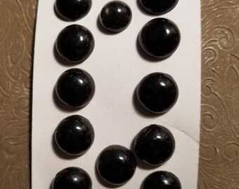 Twelve black plastic shoe buttons