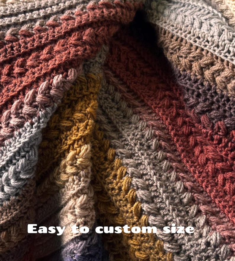 May include: Close-up of a handmade crochet blanket with a textured cable stitch design. The blanket features a gradient of colors, including shades of gray, brown, and gold. The text "Easy to custom size" is visible.