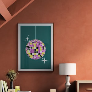 May include: A teal framed poster with a white disco ball hanging from the ceiling. The disco ball is made of mirrored tiles in shades of purple, yellow, and black. The poster is hanging on a wall with a light orange color.