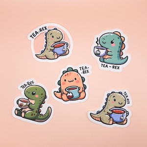 May include: Five colorful cartoon dinosaur stickers with the text "Tea-Rex" on each. Each dinosaur is holding a teacup with a tea bag.