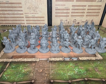 May include: A collection of gray miniature figurines, likely for a tabletop game, arranged on a game board. The figurines depict various characters, including figures with staffs and cloaks. The game board has a green and brown grid pattern.