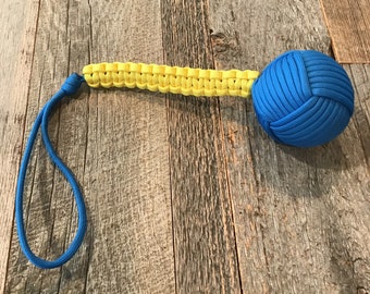 May include: A blue and yellow paracord keychain with a knotted ball at the end.