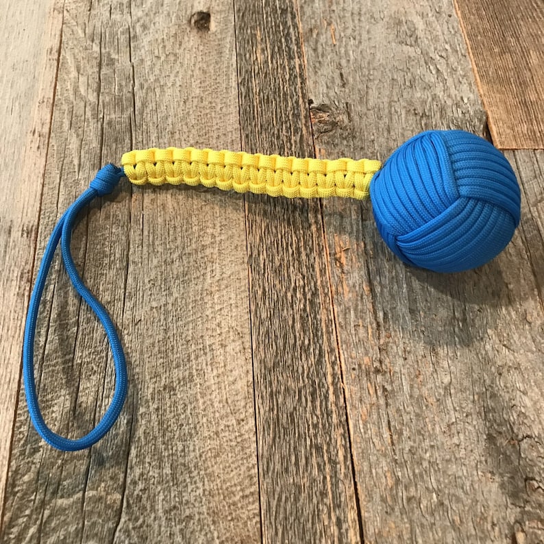 May include: A blue and yellow paracord keychain with a knotted ball at the end.