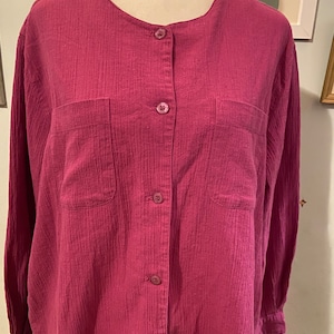 May include: A long-sleeved, button-up shirt in a deep pink color. The shirt has a relaxed fit and features two patch pockets on the front.