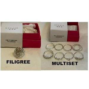 May include: A Studio 1885 silver-tone filigree ring in a pink and white box labeled Filigree, and a set of eight silver-tone rings in a pink and white box labeled Multiset, featuring various band designs and textures.
