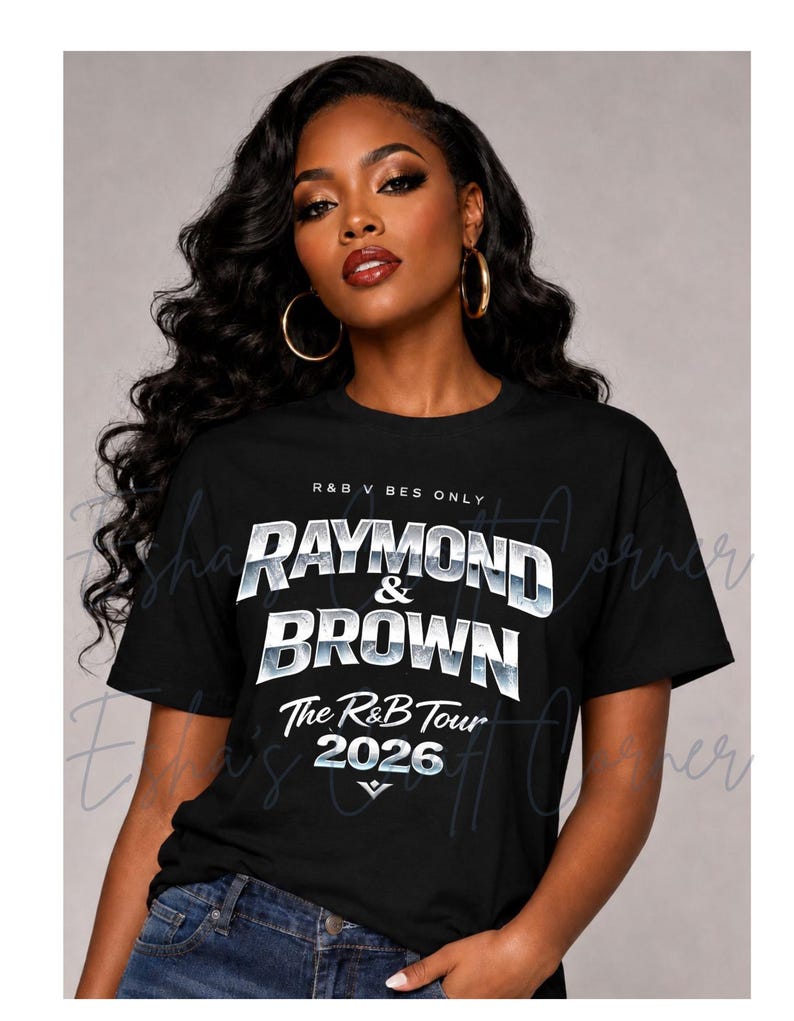May include: Black t-shirt with the text "RAYMOND & BROWN The R&B Tour 2026" in a silver and white design. The shirt also has the text "R&B V BES ONLY" at the top. The model is wearing blue jeans and gold hoop earrings.