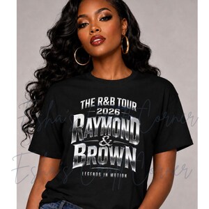 May include: Black t-shirt featuring the text "THE R&B TOUR 2026 RAYMOND & BROWN LEGENDS IN MOTION" in a silver, metallic font. The shirt is worn by a person with dark hair and gold hoop earrings.