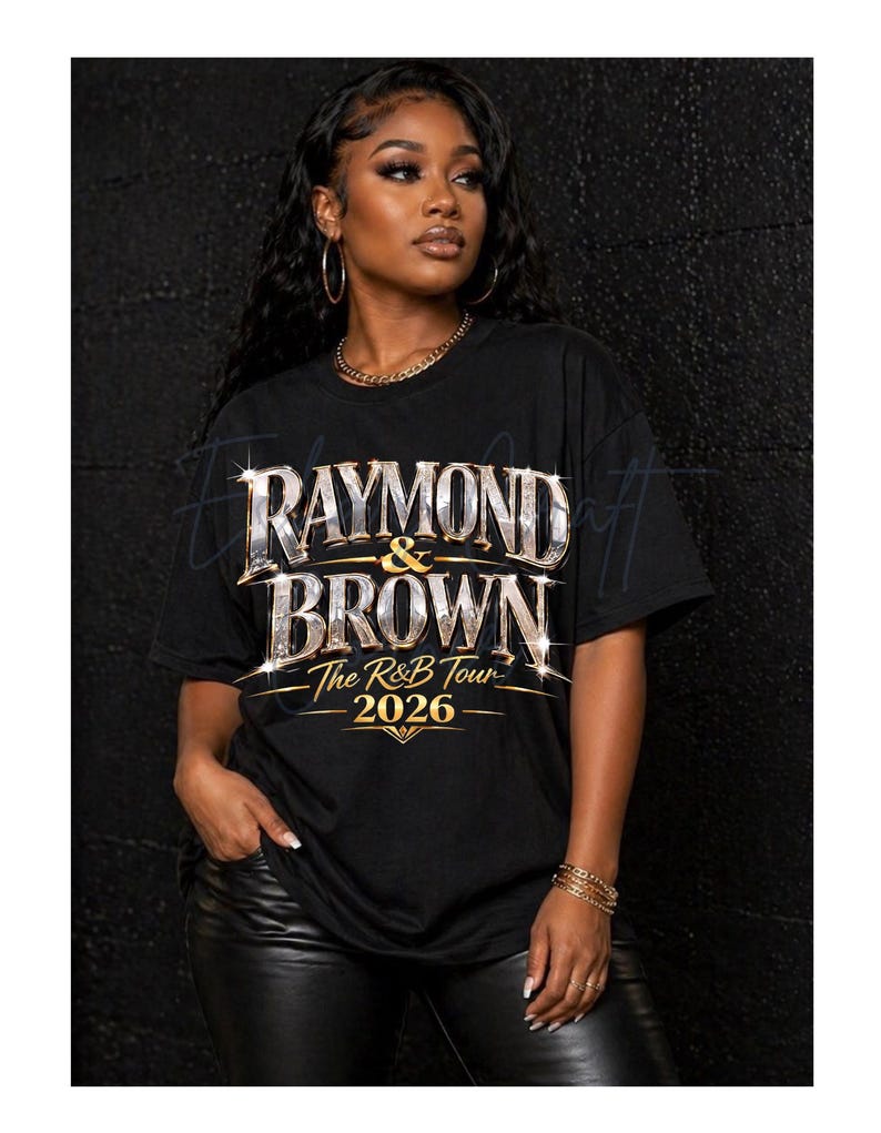 May include: Black t-shirt with the text "RAYMOND & BROWN The R&B Tour 2026" in a silver and gold design. The shirt is worn by a person with long, dark hair and gold jewelry.