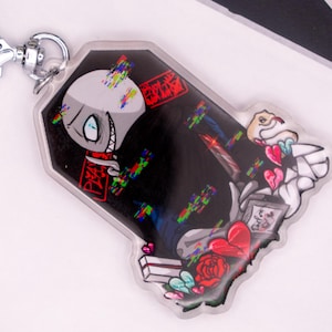 Puede incluir: Un llavero acrílico transparente con un diseño de esqueleto de dibujos animados. El esqueleto tiene un efecto de fallo y está sobre un fondo negro con corazones, rosas y cuchillos. El llavero tiene un cierre plateado y el texto "3DDREAM PRINTING".
