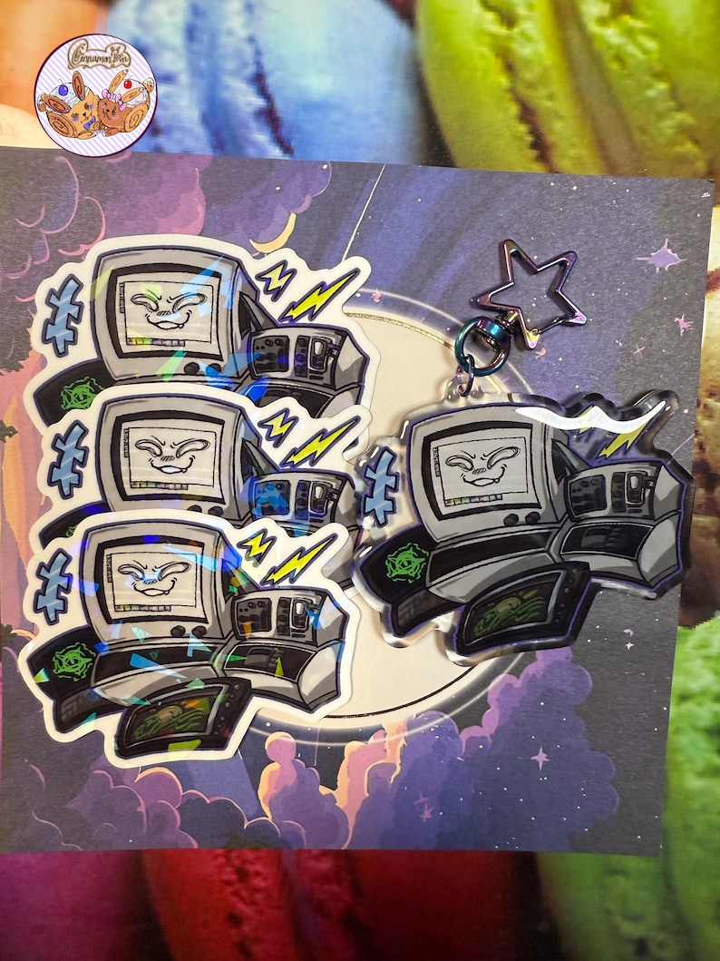 May include: A collection of stickers and a keychain showcasing a retro computer design with a smiling face on the screen. The stickers and keychain have a holographic effect, with lightning bolts and a star-shaped charm.