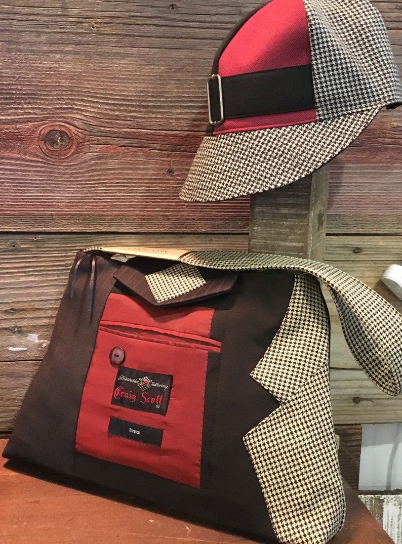 May include: A handmade bag and hat set. The bag is made from a dark brown fabric with a red pocket and a houndstooth pattern. The hat is red and houndstooth with a black band. The bag has the text "Craig Scott".