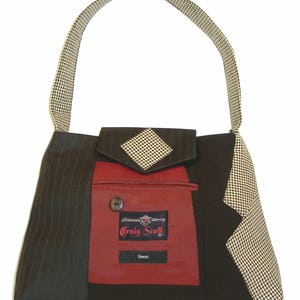 May include: A unique handbag with a houndstooth handle and accents. The bag features a red pocket with a button and a label that reads "Craig Scott". The bag is made from pinstripe and solid black fabric.
