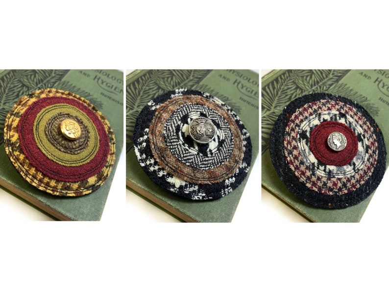 May include: Three round fabric brooches with different patterns and colors. Each brooch has a button in the center. The brooches are on a green book with text that says "Physiology and Hygiene".
