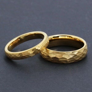 May include: Two gold wedding bands with a hammered texture.