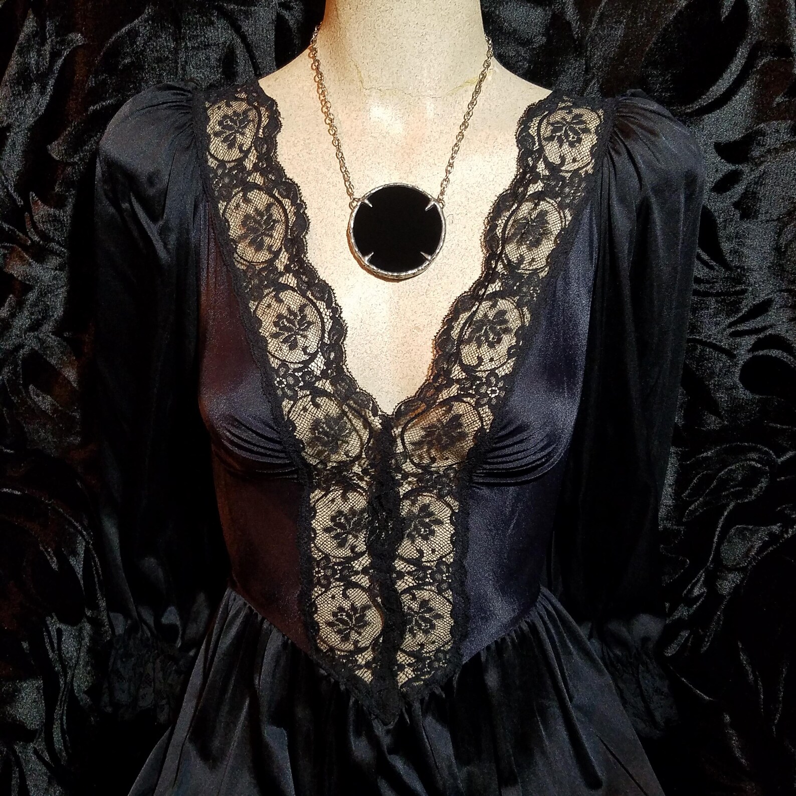 Black obsidian scrying necklace with talon setting on mannequin wearing a vintage lace gothic dress
