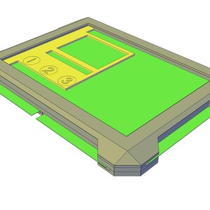 Puede incluir: Una caja de plástico gris con un interior verde y un inserto amarillo con los números 1, 2 y 3.