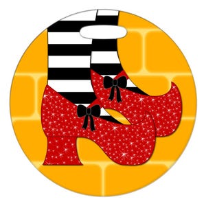 May include: Red sparkly shoes with black bows and a black and white striped leg on a yellow brick background.