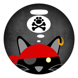 Może przedstawiać: Czarny kot z czerwoną bandaną i opaską na oku śni o czaszce i skrzyżowanych kościach z odciskami łap. Kot ma złoty kolczyk.