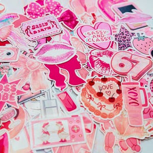 May include: A collection of pink stickers with various designs, including lips, bows, a cake with cherries, and the text "Sassy Birth" and "Sassy and Classy". The stickers are in shades of pink and white.