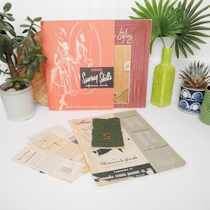 May include: A collection of vintage sewing books and pamphlets. The books are titled "Singer Sewing Skills Reference Book", "Styling", "How to Sew Curtains, Draperies, Slip Covers", and "Florence La Ganke Home Economics Consultant".