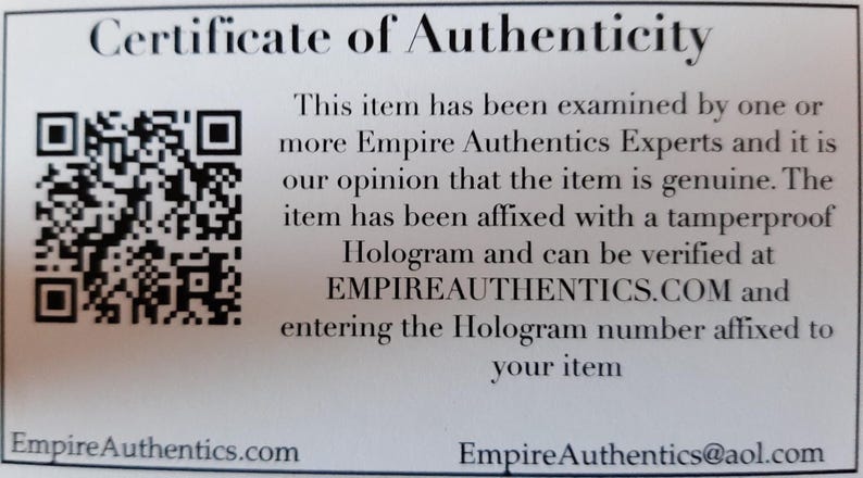 May include: A white certificate of authenticity with a black and white QR code in the upper left corner. The text reads "Certificate of Authenticity" and "This item has been examined by one or more Empire Authentics Experts and it is our opinion that the item is genuine. The item has been affixed with a tamperproof Hologram and can be verified at EMPIREAUTHENTICS.COM and entering the Hologram number affixed to your item." The bottom of the certificate reads "EmpireAuthentics.com" and "EmpireAuthentics@aol.com".