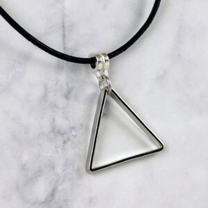 May include: A silver triangle pendant necklace with a black leather cord.