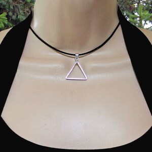 May include: A silver triangle pendant necklace on a black leather cord.