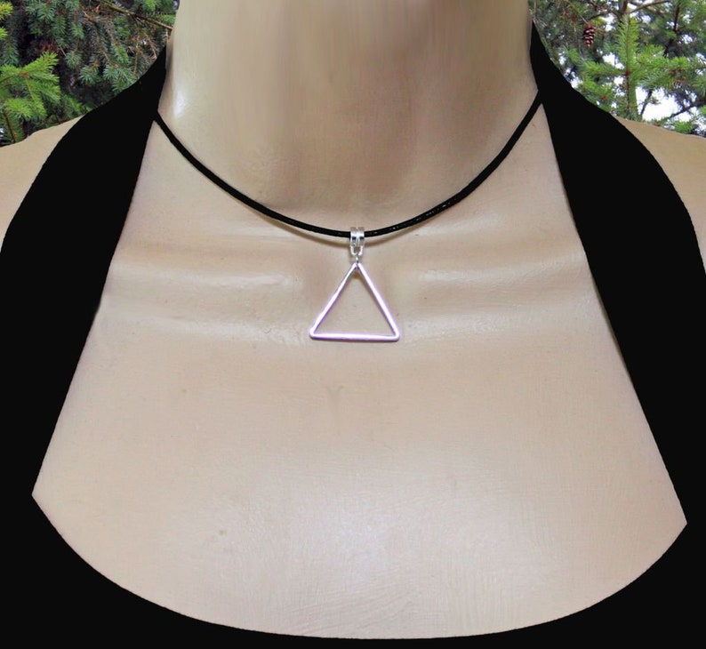 May include: A silver triangle pendant necklace on a black leather cord.