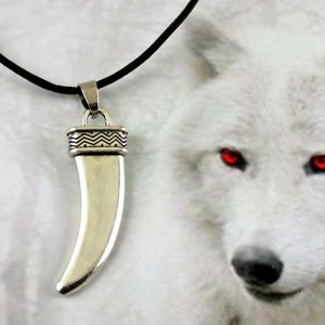 May include: A silver wolf fang pendant necklace with a black leather cord. The pendant has a detailed design and is a popular symbol of strength and loyalty.