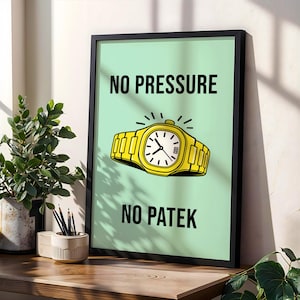 Op de afbeelding: Een ingelijste kunstdruk met een lichtgroene achtergrond en zwarte tekst die luidt "NO PRESSURE NO PATEK". Een gele polshorloge-illustratie is gecentreerd tussen de tekst. De print zit in een zwart frame en staat op een houten oppervlak.