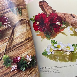 May include: A set of handmade jewelry featuring red hibiscus flowers, white plumeria flowers, and green leaves. The jewelry includes a necklace, earrings, and a hair comb.