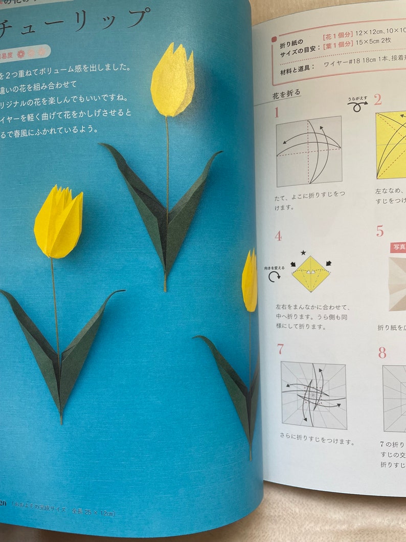 May include: A step-by-step guide on how to fold a paper origami tulip. The instructions are written in Japanese. The image shows a yellow origami tulip with green leaves.