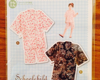 May include: Two children's jinbei, a traditional Japanese summer garment. The first is white with pink flowers, the second is black with a blue and white pattern. The text on the page reads "Schoolchild Jinbei".