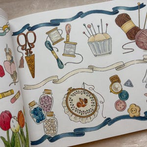 May include: An illustrated page with sewing and crafting items. The image shows scissors, thread spools, a pincushion, yarn, an embroidery hoop, buttons, and jars of beads. A blue ribbon and decorative banners are also included.