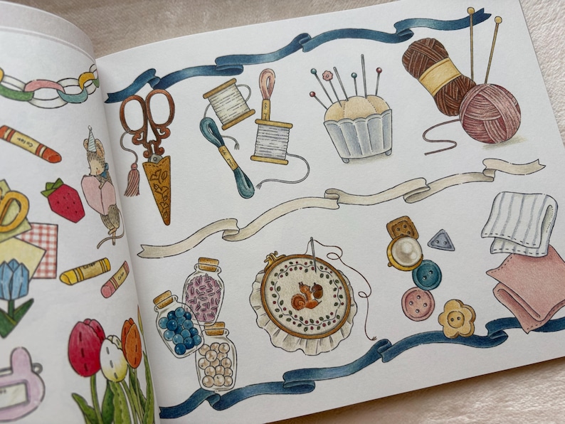 May include: An illustrated page with sewing and crafting items. The image shows scissors, thread spools, a pincushion, yarn, an embroidery hoop, buttons, and jars of beads. A blue ribbon and decorative banners are also included.