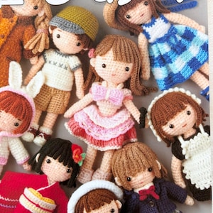 May include: A collection of handmade crochet dolls, each with unique outfits and hairstyles. The dolls are dressed in various styles, including a sailor outfit, a pink dress, and a traditional Japanese kimono. The image includes the text "Pomadour's".