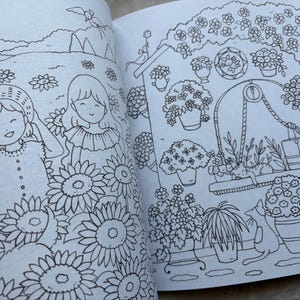 May include: A black and white illustration from a coloring book featuring two smiling girls in a field of sunflowers. The illustration also depicts a garden scene with potted flowers, a cat, and a well.