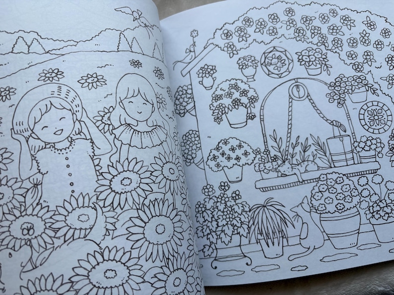 May include: A black and white illustration from a coloring book featuring two smiling girls in a field of sunflowers. The illustration also depicts a garden scene with potted flowers, a cat, and a well.