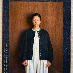 May include: A book cover featuring a woman wearing a dark denim jacket over a white top and pants. The book title reads "Lady Denim" in Japanese. The cover has a denim border and a wooden panel background.