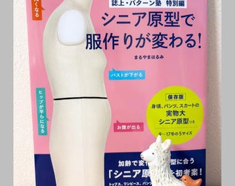 May include: A book titled "Senior Pattern and Dressmaking Changes!" in Japanese, with a pink and white cover. The book features a dress form and a small white llama figurine. The text includes Japanese characters and English text.