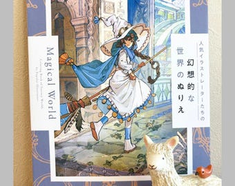Puede incluir: Un libro para colorear titulado "Magical World" con una ilustración de una bruja en una escoba. La portada es azul con patrones decorativos y texto en inglés y japonés. Una figura de llama blanca con un pájaro pequeño está frente al libro.