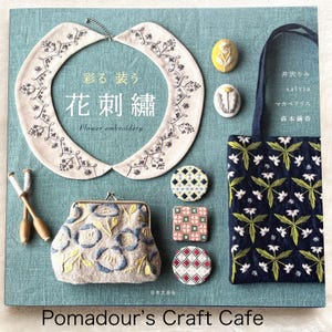 Puede incluir: Un libro titulado "Bordado de flores" con el texto japonés "彩る装う 花刺繡"  muestra varios proyectos de bordado, incluyendo un cuello, una cartera, una bolsa de mano y varios broches pequeños. La portada del libro es de color azul claro con un fondo de tela texturizada.