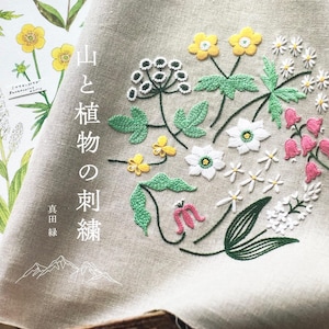May include: A beige fabric with an embroidered floral design. The embroidery features yellow, white, and pink flowers with green leaves and stems. The text "山と植物の刺繍" is visible in the image, along with the word "Pomadour's".