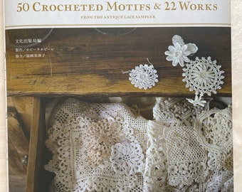 May include: A book titled "50 Crocheted Motifs & 22 Works" with Japanese text, featuring crochet patterns. The image shows a wooden drawer filled with crocheted lace and several crocheted motifs. The book is from the Antique Lace Sampler.
